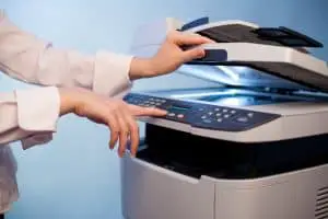 有工作複印機的女人的手