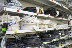 電器用品店。 貨架與貨物。 商店裡的電纜卷。 在五金店出售的電力電纜。