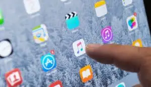 iOS 8.4 設備上的人指觸摸屏幕上的 Apple Music 應用程序，專注於“Apple Music”應用程序圖標