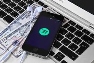 iPhone 5s 在筆記本電腦上，屏幕上帶有 Spotify 的移動應用程序。  Spotify 是提供合法流媒體音樂的瑞典音樂服務。
